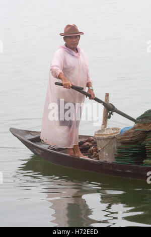 Man Rudern mit dem Boot auf dem Fluss an einem nebligen Morgen in Hoi An, Vietnam Stockfoto