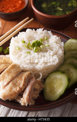 Hainan-Huhn mit Reis mit Gurke Closeup auf einen Teller geben und Brühe. vertikale Stockfoto