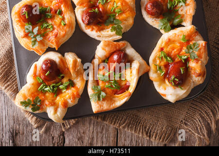 Muffins mit Wurst, Käse und Zwiebel hautnah in Auflaufform legen. horizontale Ansicht von oben Stockfoto