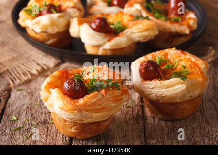 Brötchen aus Blätterteig mit Wurst und Käse Nahaufnahme auf dem Tisch. Horizontale Stockfoto