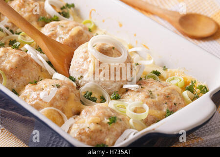 Leckere Hähnchen Kugeln gebacken in Käse-Sahne-Sauce Nahaufnahme in die Schüssel zum Backen. horizontale Stockfoto