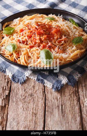 Italienische Küche: Pasta mit Amatriciana Soße, Käse und Basilikum Nahaufnahme auf einem Teller auf den Tisch. Vertikal Stockfoto