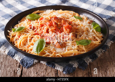 Italienische Küche: Pasta mit Amatriciana Soße, Käse und Basilikum Nahaufnahme auf einem Teller auf den Tisch. horizontale Stockfoto