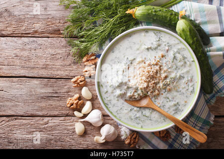 Gurken Suppe Tarator in eine Schüssel geben und die Zutaten auf den Tisch. horizontale Ansicht von oben Stockfoto