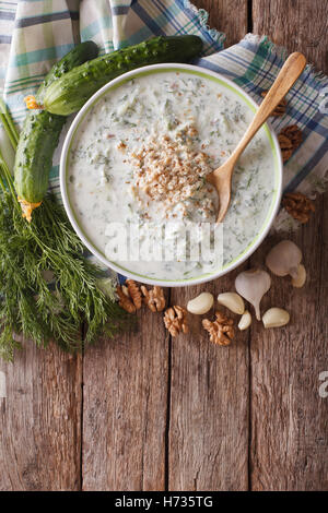 Gurken Suppe Tarator in eine Schüssel geben und die Zutaten auf den Tisch. vertikale Ansicht von oben Stockfoto