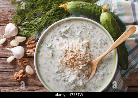 Bulgarische Tarator Suppe hautnah in eine Schüssel geben und die Zutaten auf den Tisch. horizontale Ansicht von oben Stockfoto