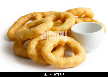 Haufen von tiefen gebratenen Zwiebeln oder Calamari Ringe mit Dip-Schale isoliert auf weiss. Stockfoto