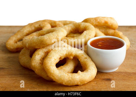 Haufen von tiefen gebratenen Zwiebeln oder Calamari Ringe mit Chili-Dip auf Holzplatte. Stockfoto