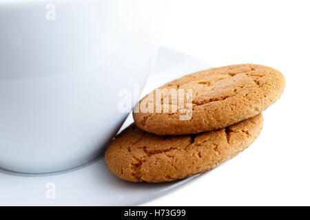 Detail der zwei Ingwer Kekse mit Tasse und Untertasse. Weißen Hintergrund. Stockfoto