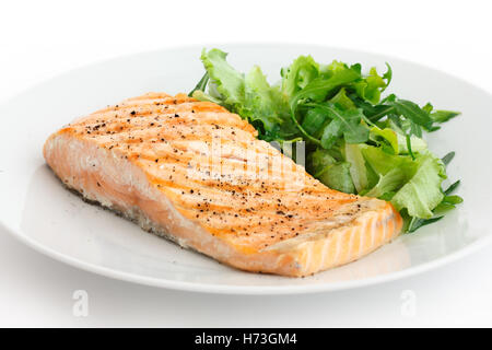 Gegrilltes Filet vom Lachs auf Teller mit grünem Salat. Stockfoto