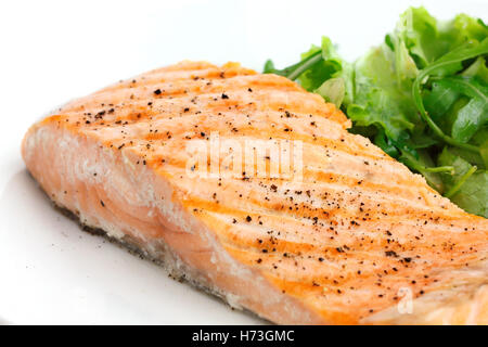Gegrilltes Filet vom Lachs auf Teller mit grünem Salat. Stockfoto