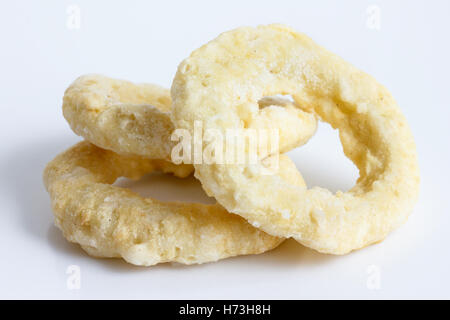Drei gefrorenen roh angeschlagenen Zwiebel oder Calamari Ringe isoliert auf grau. Stockfoto