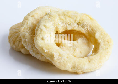 Drei gefrorenen roh angeschlagenen Zwiebel oder Calamari Ringe isoliert auf grau. Stockfoto