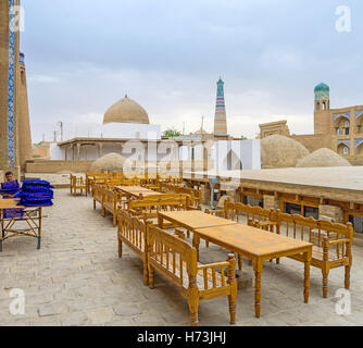 Das Café im Freien vor Allakuli Khan Madrasah mit Blick auf die Oq-Moschee und die hohe Islam Khoja Minarett Stockfoto