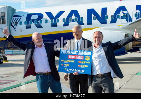 David O· Brien (L-R, Chief Commercial Officer bei Ryanair), Stefan Schulte (Vorstandsvorsitzender der Fraport AG) und Kenny Jacobs (Chief Marketing Officer Ryan Air) Stand mit einem Schild, dass liest "Frankfurt Am Main neue Basis" am Flughafen in Frankfurt am Main, Deutschland, 2. November 2016. Zwei Lufthansa-Flugzeuge können im Hintergrund zu sehen. Flughafenbetreiber Fraport und der irischen Diskont Fluggesellschaft Ryanair liefern Aussagen auf einer gemeinsamen Pressekonferenz auf zukünftige Angebote von Ryanair am Flughafen Frankfurt Am Main. Zu diesem Anlass ein Flugzeug von Rynair zum ersten Mal auf dem Flughafen gelandet. Foto: A Stockfoto