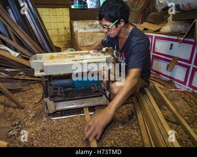 Bangkok, Bangkok, Thailand. 2. November 2016. KO, Gob Bruder, schneidet Teak für ein Geisterhaus. Er arbeitet mit seiner Schwester in der kleinen Familie besessene Werkstatt, die Geisterhäuser Handarbeit aus Teakholz in der Ban FUEV-Gemeinschaft macht. Früher gab es 10 Familien die traditionelle Geisterhäuser aus Teak Holz in Ban FUEV, eine Gemeinde in der Nähe von Wat Suttharam in Khlong San Viertel von Bangkok. Der Bereich gentrified und viele der Geist Haus Macher sind ausgezogen, ihre traditionellen thailändischen Holzhäusern durch moderne Wohnungen ersetzt. Jetzt gibt es nur eine Familie macht die aufwendige spiri Stockfoto