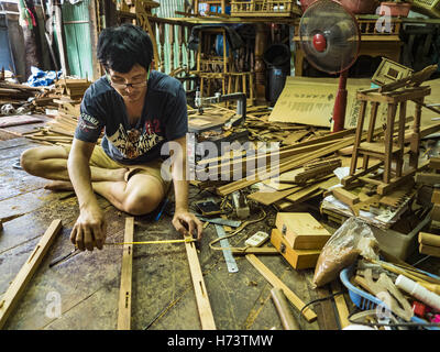 Bangkok, Bangkok, Thailand. 2. November 2016. KO, Gob Bruder, Weiterbildungsangebote Teak für ein Geisterhaus. Er arbeitet mit seiner Schwester in der kleinen Familie besessene Werkstatt, die Geisterhäuser Handarbeit aus Teakholz in der Ban FUEV-Gemeinschaft macht. Früher gab es 10 Familien die traditionelle Geisterhäuser aus Teak Holz in Ban FUEV, eine Gemeinde in der Nähe von Wat Suttharam in Khlong San Viertel von Bangkok. Der Bereich gentrified und viele der Geist Haus Macher sind ausgezogen, ihre traditionellen thailändischen Holzhäusern durch moderne Wohnungen ersetzt. Jetzt gibt es nur eine Familie macht die aufwendige sp Stockfoto