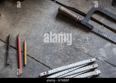 Alte Werkzeuge auf die alte Werkstatt, Holztisch, Maßnahme, Säge, Bleistifte Stockfoto