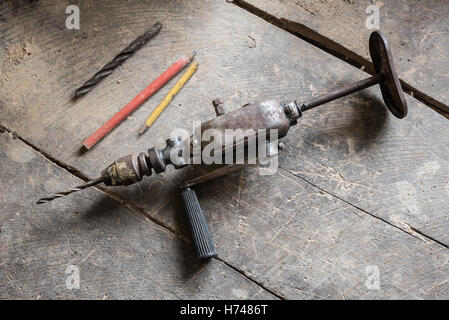 Alte Werkzeuge auf der staubigen Workshop, Holztisch, Bleistifte und Bohrer Stockfoto