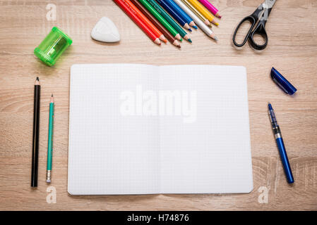 Schüler Schreibtisch mit Notebook, Bleistift, Buntstifte, Kugelschreiber, Schere, Spitzer, Kautschuk drauf. Flach zu legen Stockfoto