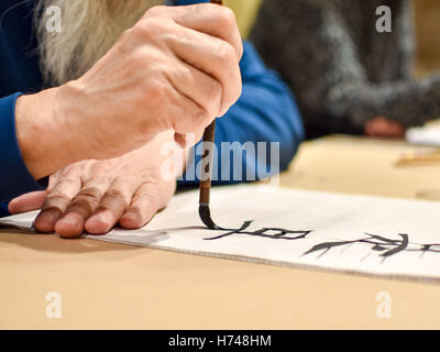 Kalligraphie Meister Zeichnung chinesischen Schriftzeichen mit einem Pinsel Stockfoto