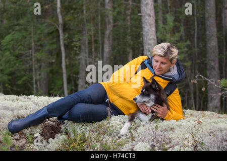 Frau - Tourist ist die Verlegung an den Wald Wiese mit einem Hund Stockfoto