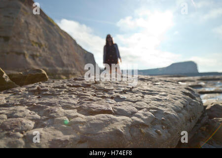 Eine unbekannte Frau steht in der felsigen Landschaft nahe Staithes auf der Yorkshire Coast, England UK Stockfoto