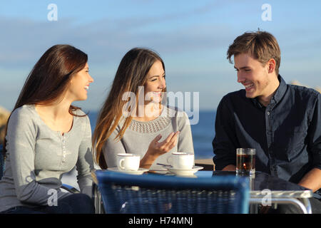 Freunde sprechen in einem Restaurant am Strand Stockfoto