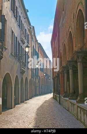 Die einsame Straße verläuft durch die Stadtlabyrinth der mittelalterlichen Gassen, Arkaden, kleine Kapellen und antiken Ruinen voller Stockfoto