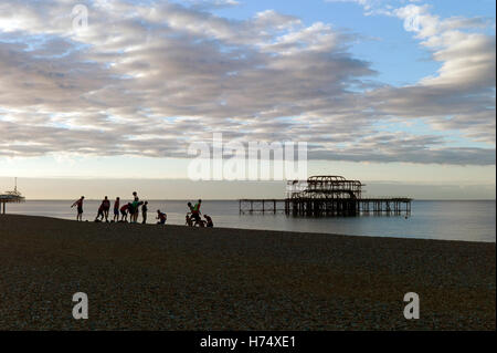 Menschen, die Übung am Strand neben dem verlassenen Pier West, Brighton, UK Stockfoto