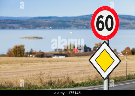 Hauptstraße gelbe Roadsign mit Tempolimit Schild montiert auf einer Metallstange in der Nähe von norwegischen Landstraße Stockfoto