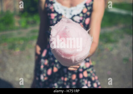 Eine junge Frau trägt eine Kleid steht außerhalb einer Zuckerwatte an einem sonnigen Sommertag mit Stockfoto