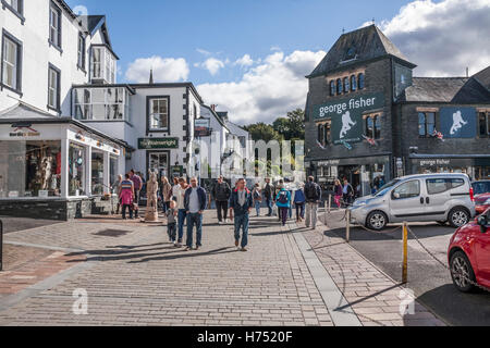 Touristen zu Fuß entlang der viel befahrenen See-Straße in Keswick, Lake District, Cumbria, England Stockfoto