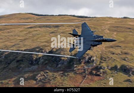 Ein f-15-Jet wird von CAD-West, als es niedrigen Niveau durch die Schleife, Machynlleth in Wales, eine Reihe von Tälern durch ihre Verwendung als Low-Level-Übungsplätze für schnellen Jet-Flugzeugen fliegt gesehen. Stockfoto