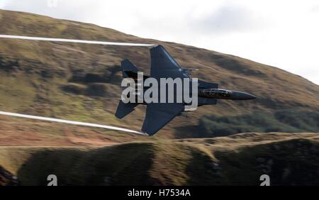 Ein f-15-Jet wird von CAD-West, als es niedrigen Niveau durch die Schleife, Machynlleth in Wales, eine Reihe von Tälern durch ihre Verwendung als Low-Level-Übungsplätze für schnellen Jet-Flugzeugen fliegt gesehen. Stockfoto