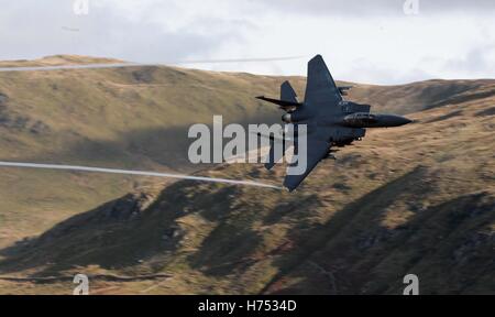 Ein f-15-Jet wird von CAD-West, als es niedrigen Niveau durch die Schleife, Machynlleth in Wales, eine Reihe von Tälern durch ihre Verwendung als Low-Level-Übungsplätze für schnellen Jet-Flugzeugen fliegt gesehen. Stockfoto