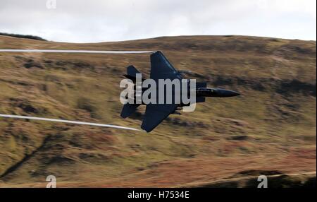 Ein f-15-Jet wird von CAD-West, als es niedrigen Niveau durch die Schleife, Machynlleth in Wales, eine Reihe von Tälern durch ihre Verwendung als Low-Level-Übungsplätze für schnellen Jet-Flugzeugen fliegt gesehen. Stockfoto