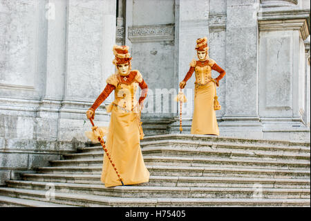 Zwei Frauen in wunderschönen Kleidern und Masken in Venedig Stockfoto