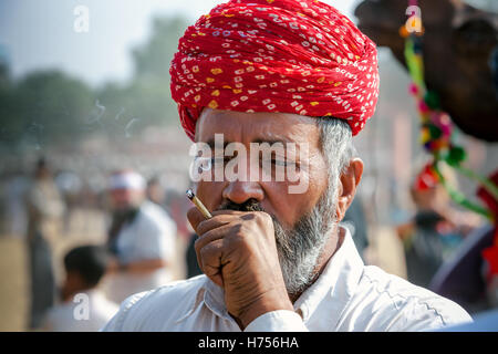 Porträt von einem nicht identifizierten Rauchen Rajasthani indische Mann besucht das Pushkar Fair. Stockfoto