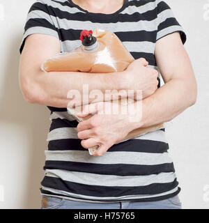 Mann hält Plastiktüte mit Wasserhahn voll von Apfelsaft Stockfoto