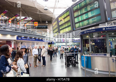 Zwei junge Chinesinnen sieht bei der Infotafel für die aktuellen Abflüge von Manchester Piccadilly Station. Stockfoto