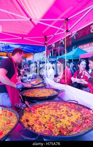 LONDON, Vereinigtes Königreich - 11. September 2016: Ein spanischer Mann serviert authentische Paella an einen Kunden in Portobello Road Market. Stockfoto