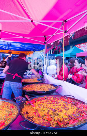 LONDON, Vereinigtes Königreich - 11. September 2016: Ein spanischer Mann serviert authentische Paella an einen Kunden in Portobello Road Market. Stockfoto