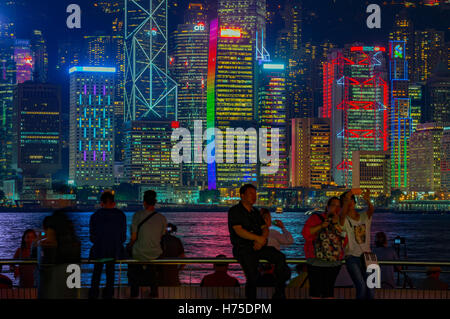 Der berühmte Tsim Sha Tsui Promenade, und Touristen genießen den Abend Blick auf Hong Kong Island, Hongkong, China. Stockfoto