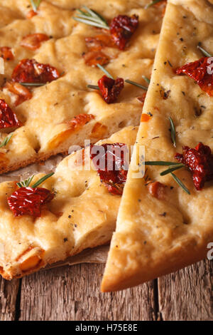 In Scheiben geschnitten italienische Focaccia mit getrockneten Tomaten und Rosmarin auf einem Tisch. Makro vertikalen Stockfoto