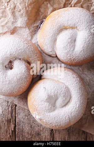 Spanische Ensaimadas süße Brötchen mit Puderzucker Nahaufnahme auf dem Tisch. vertikale Ansicht von oben Stockfoto