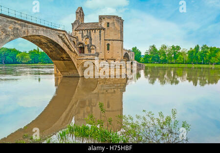 Die Pont d’Avignon (Pont Saint-Benezet) an der Rhone mit der Chapelle Saint Nicolas und ihrer klaren Reflexion auf der Oberfläche des Flusses, Avignon, Frankreich Stockfoto