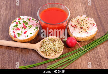 Frisch zubereitete vegetarische Sandwich mit Käse, Gemüse, Luzerne und Radieschen Sprossen, Glas Tomatensaft, gesunde Stockfoto