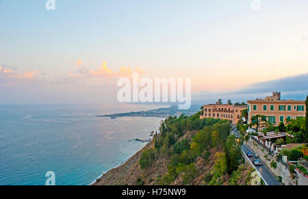 Der Sonnenuntergang über ionische Meeresküste von den Hängen des Taormina, Giardini Naxos Resort auf den Hintergrund, Sizilien, Italien. Stockfoto