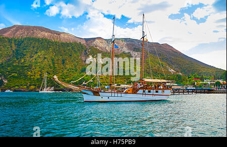 Alte ist hölzerne in Porto di Levante startklar für die touristische Reise Insel Vulcano mit großen Krater auf dem Hintergrund Stockfoto